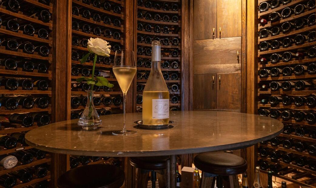 Wine cellar with a bottle of white wine on a table.