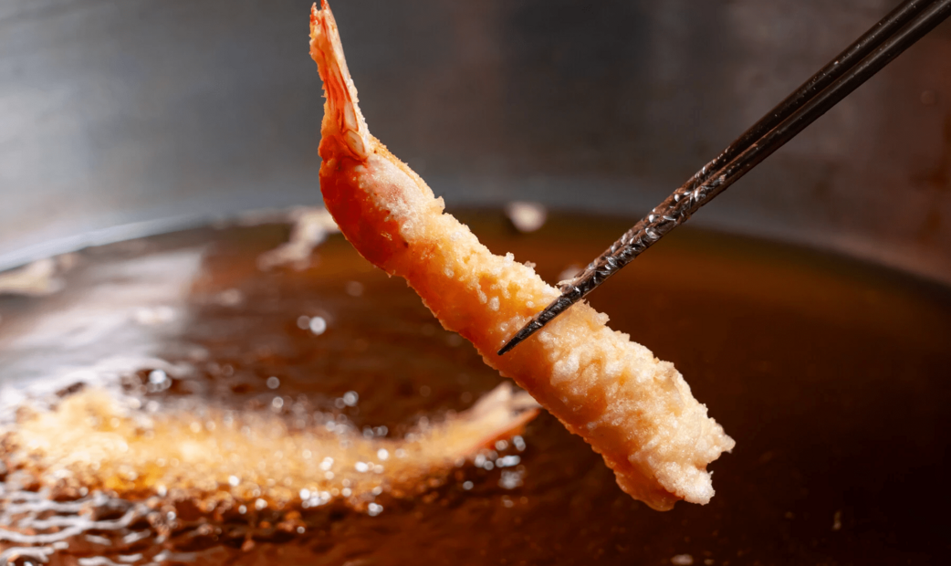 A shrimp tempura picked by a chop-stick