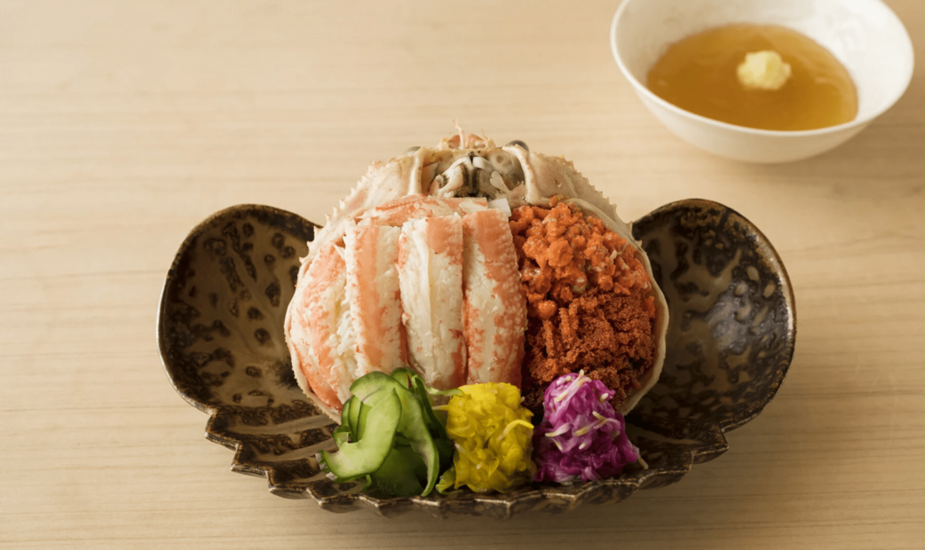 A crab with vegetable pickles aside