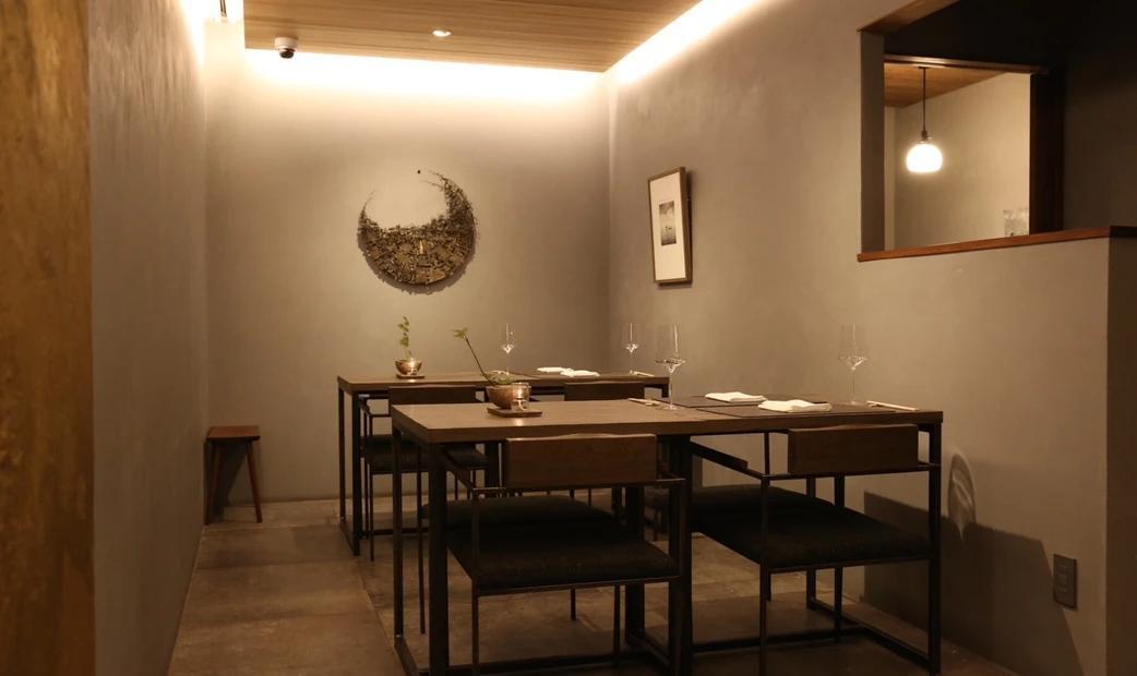 A minimalist restaurant interior with subdued lighting and simple decor.