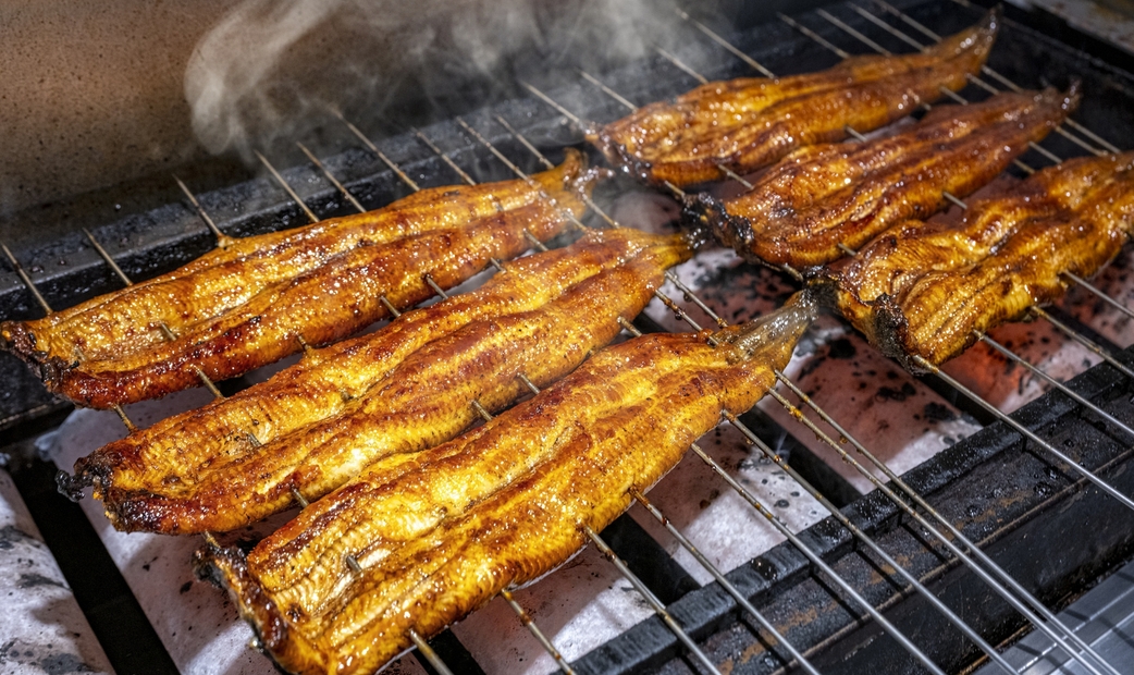 Eels being grilled over charcoal