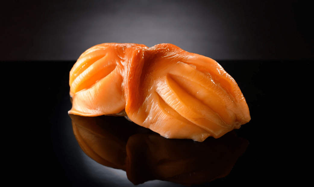 orange colored sushi spotted on black background